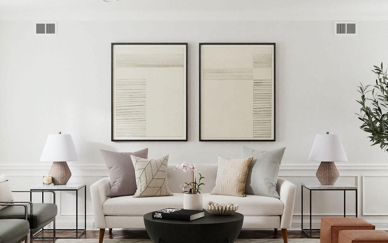  A brightly lit living room features a long, light-colored sofa adorned with various throw pillows in neutral tones.