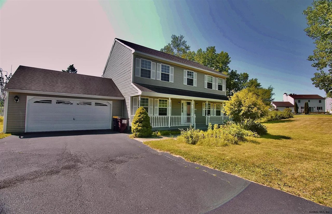 Gray two-story house with an attached double garage, covered porch, and wide driveway.