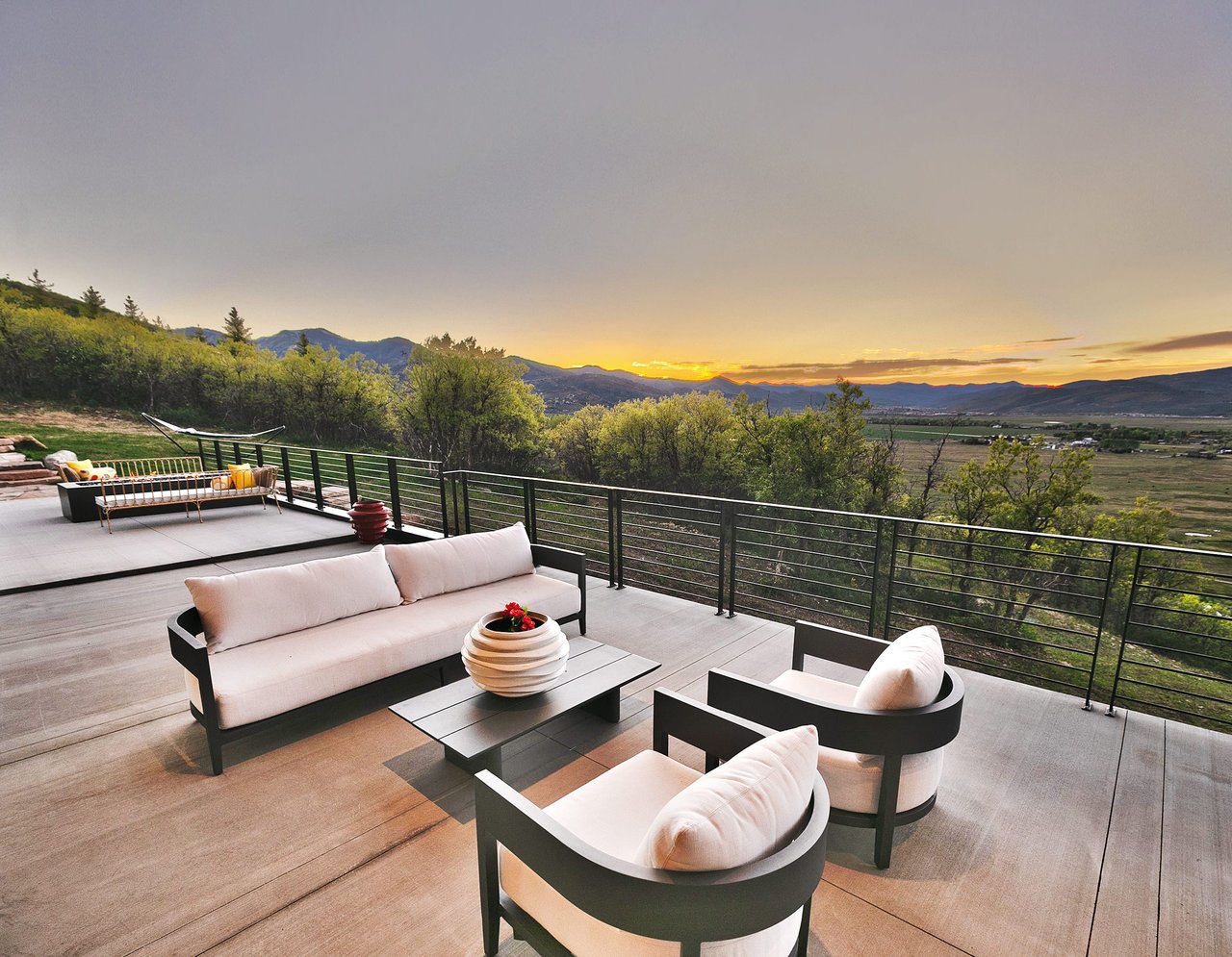 Outdoor patio furniture overlooking a valley at sunset