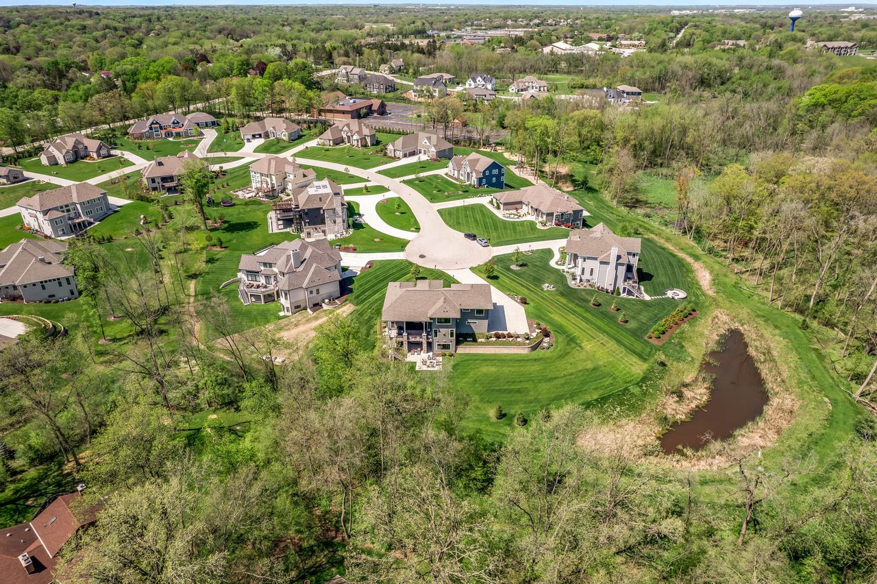 Brookfield, WI residential area aerial shot showcasing upscale houses, green lawns, and wooded surroundings