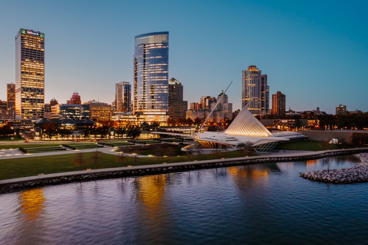 Aerial view of downtown Milwaukee at twilight, showcasing the Milwaukee Art Museum, Northwestern Mutural, University Tower, Kilbourn Towner, and other skyscrapers along the lakefront