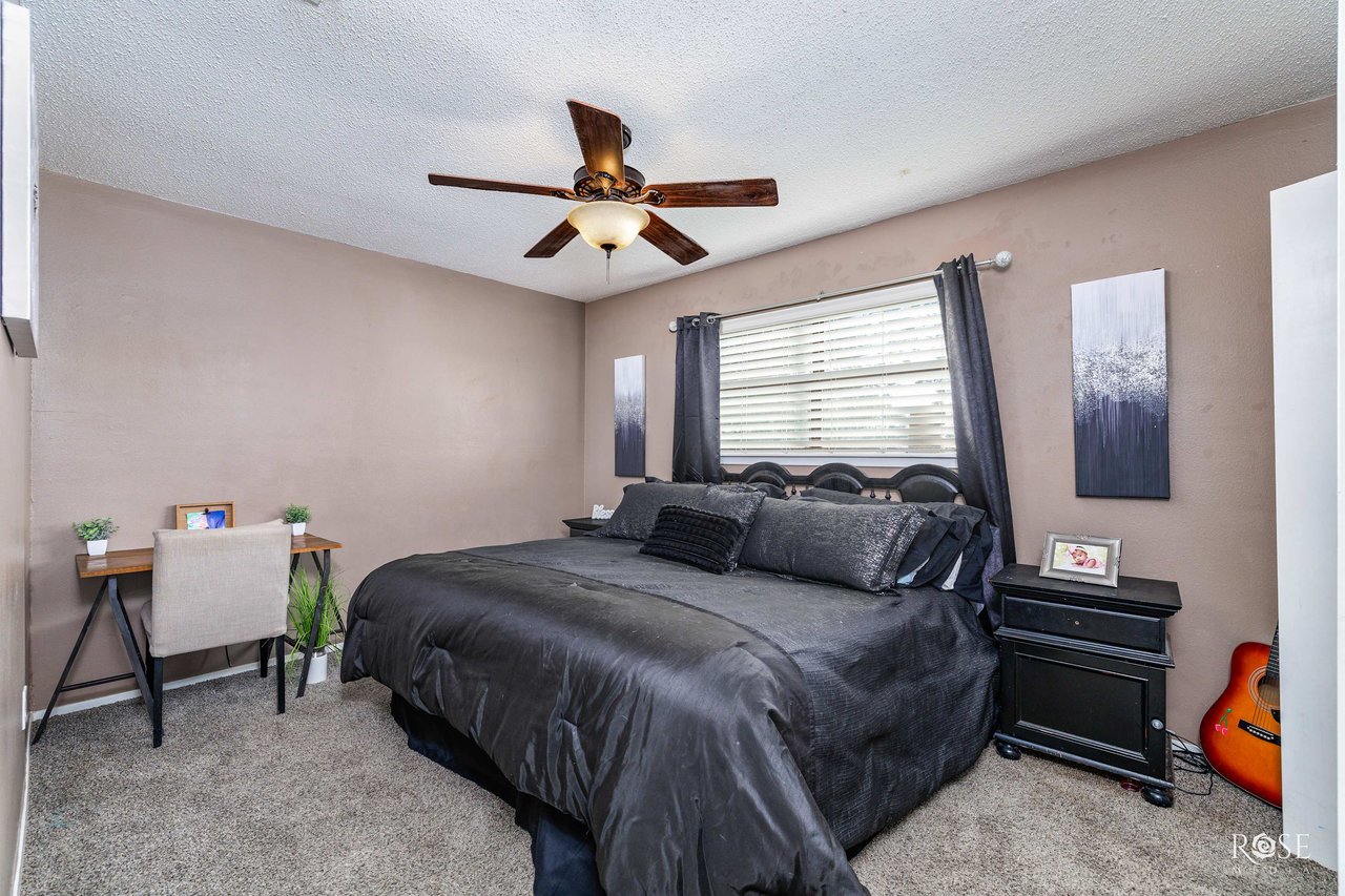 Second bedroom with natural light, neutral walls, and carpet in Veribest ISD home. Photo by Rose Media in San Angelo, TX