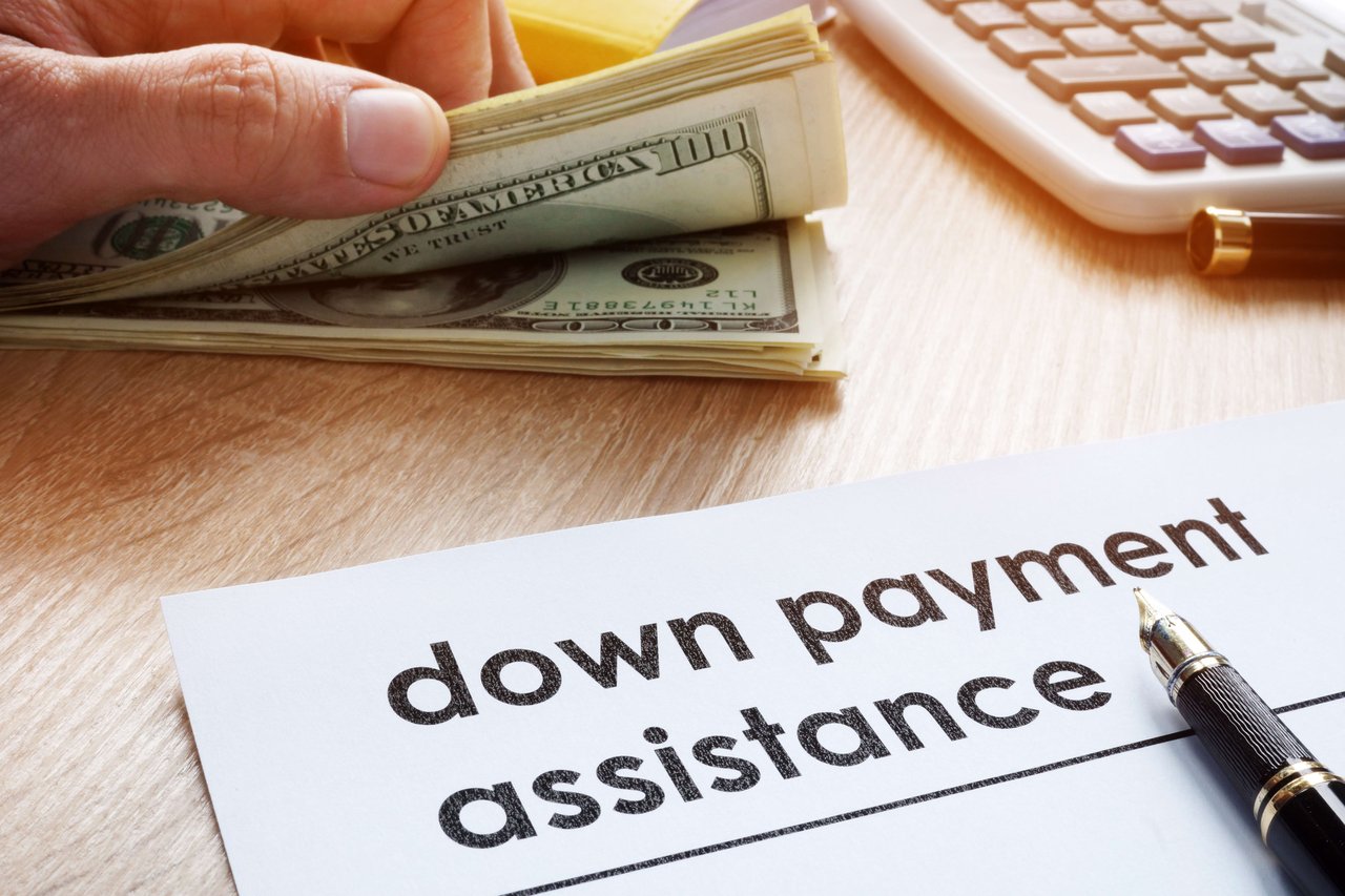 A stack of money with down payment assistance application 