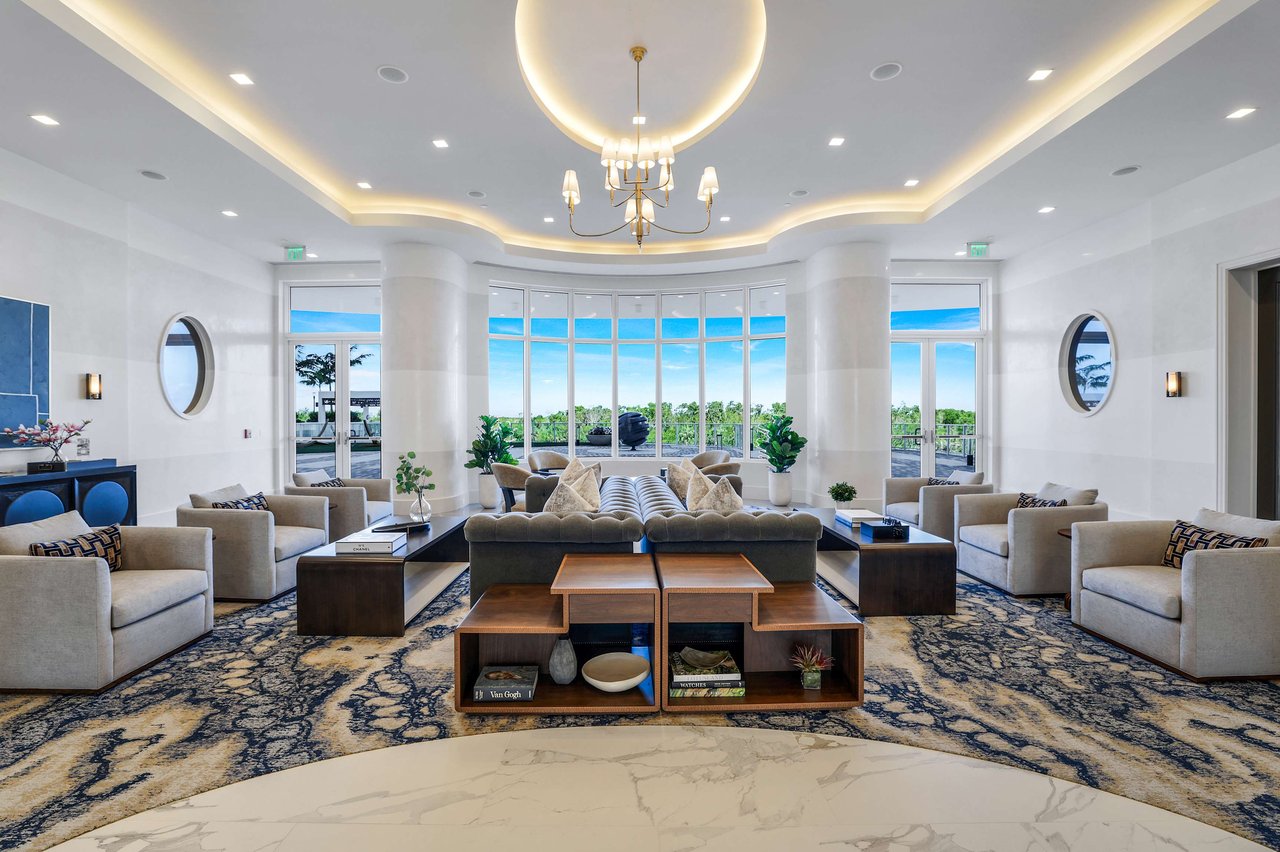 A wide shot of a modern, luxurious lounge or lobby area with a sweeping view of the ocean