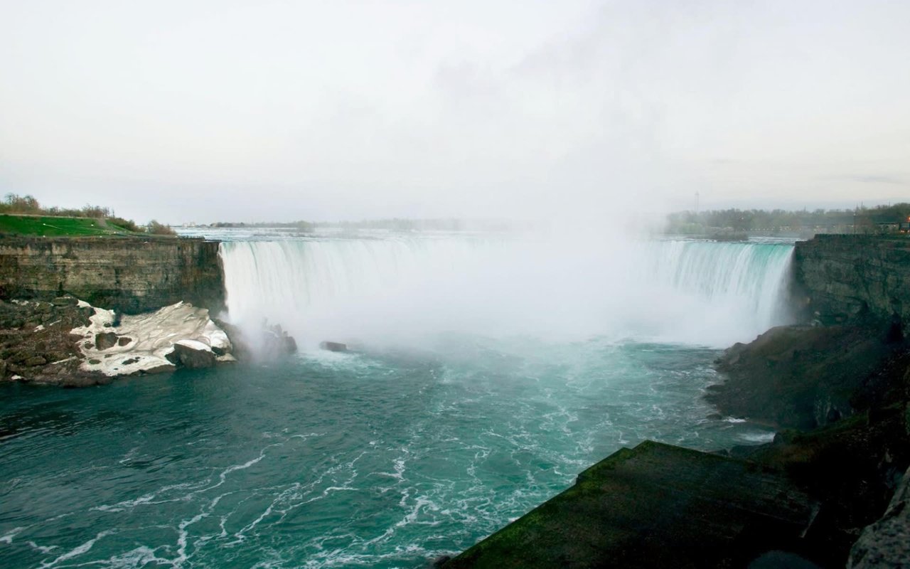 A powerful waterfall with cascading blue water and mist.