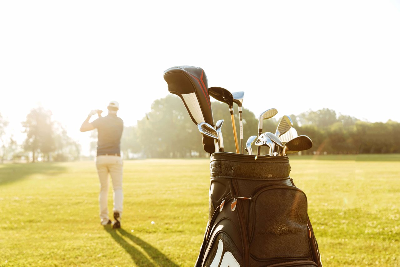 back view of a male golfer swinging a golf club