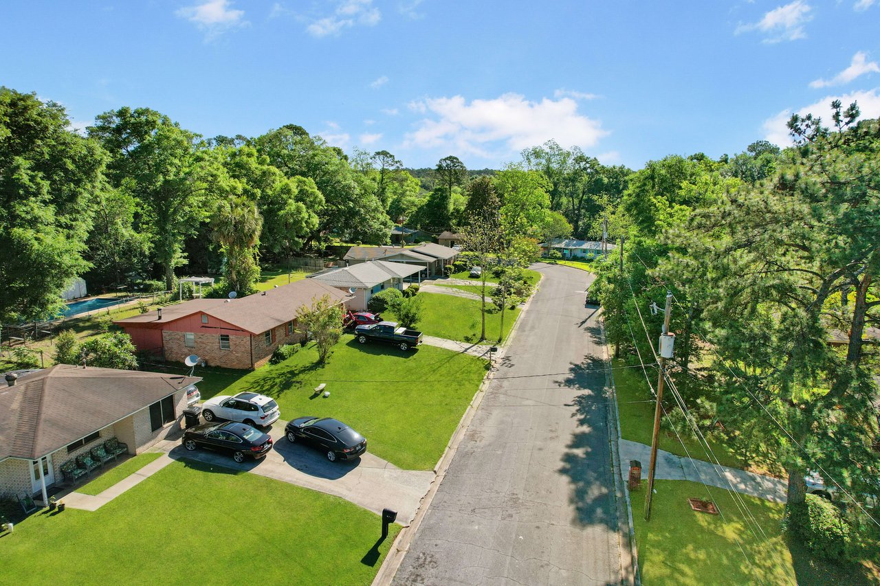 An aerial view of a residential street in the Beacon Hill neighborhood, showing houses, cars, and tree cover.