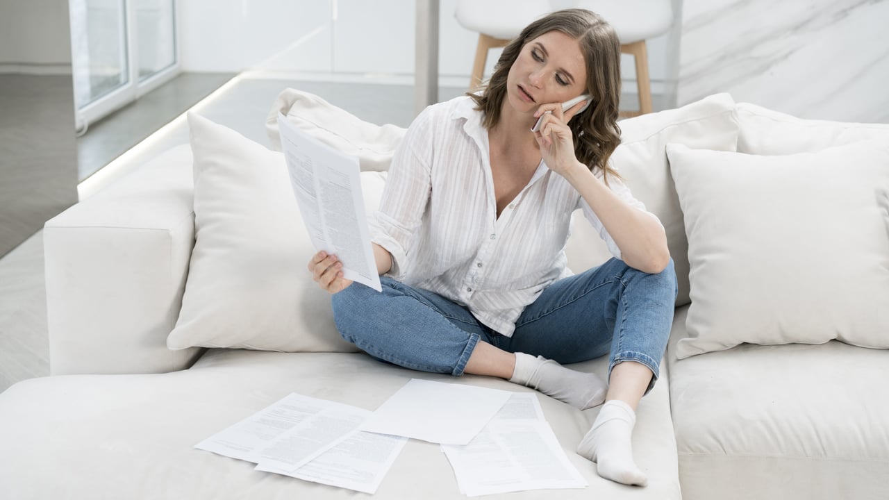 woman looking at documents while calling