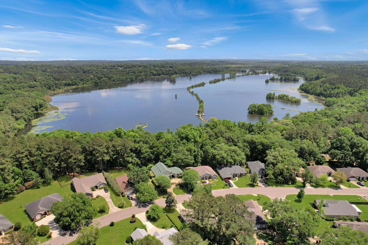 An aerial view of the Piney-Z community, featuring a lake and surrounding houses.