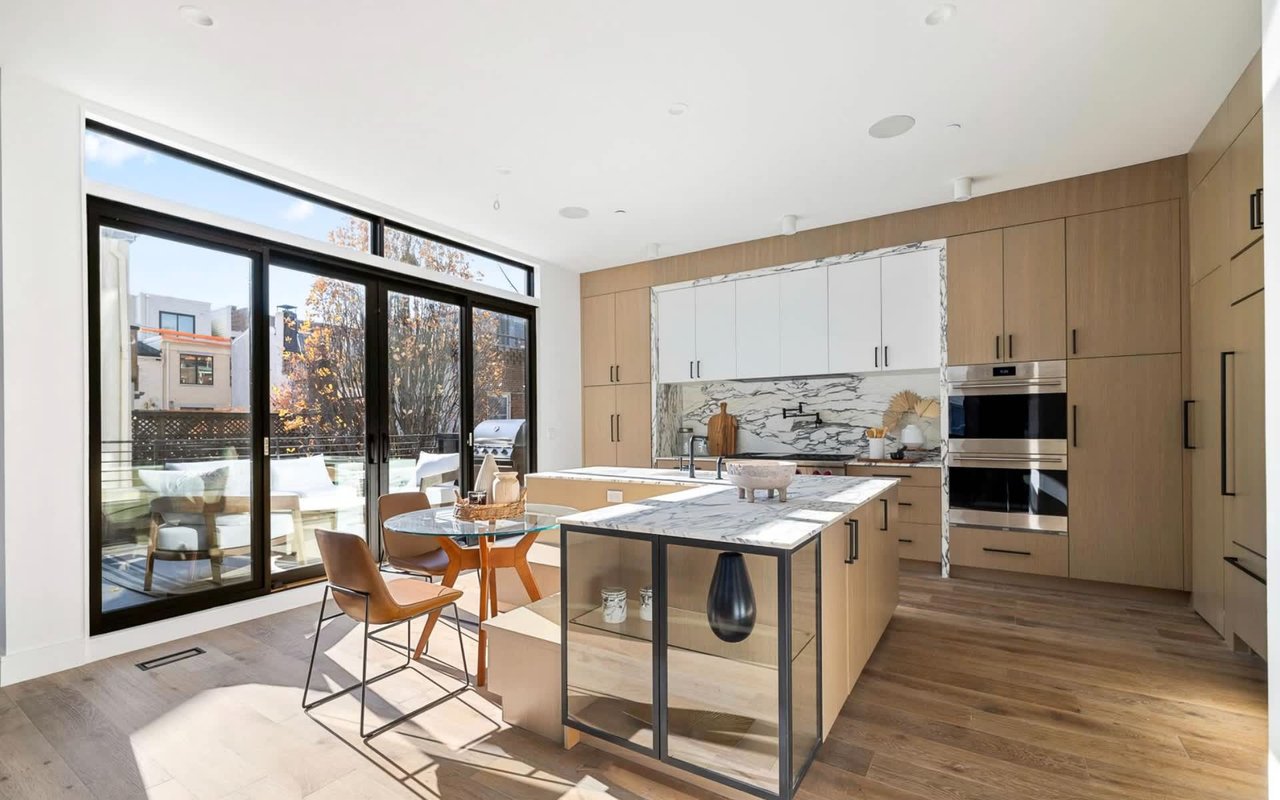 A bright and modern kitchen with white cabinets and warm wood accents.