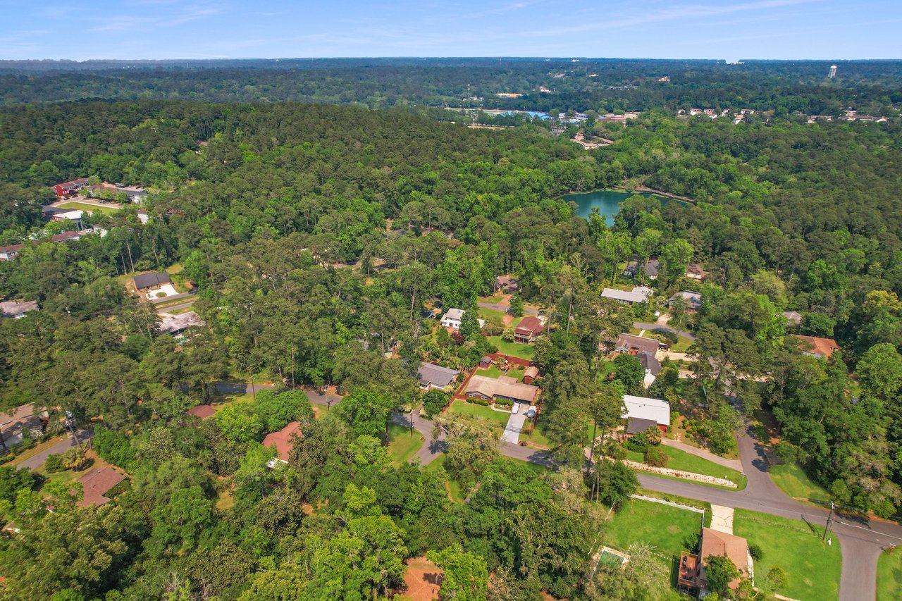 A broader view of San Luis, showing a broader perspective of the residential area, the lake, and the surrounding forested areas.