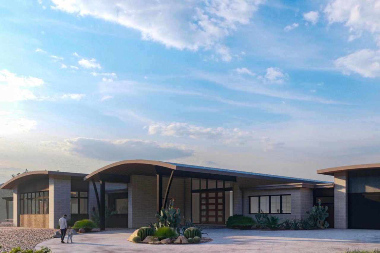Modern desert home with a curved roof, large windows, and a black car parked in the driveway.