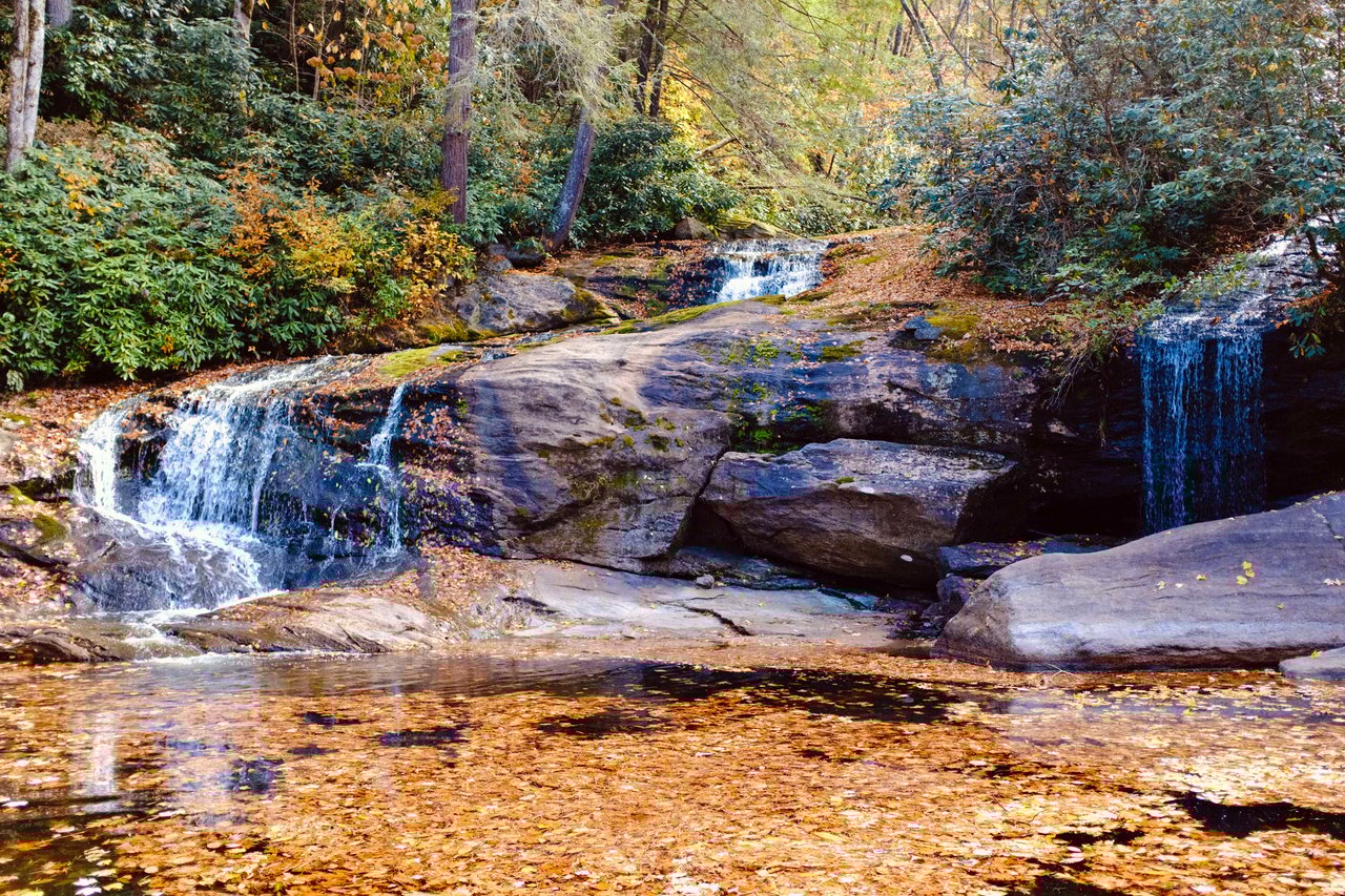a beautiful waterfall flowing into lake glenville