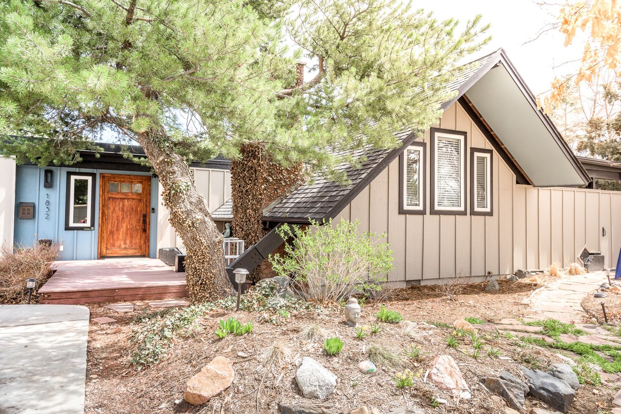 Modern Craftsman house, with covered porch, two-car garage, brown roof, and tan siding.