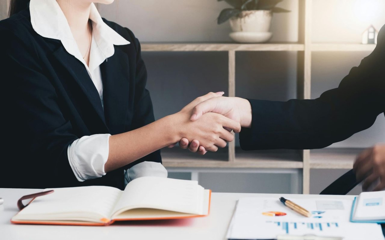 Two women shaking hands making business deal