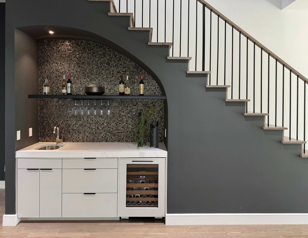 Sleek under-stair bar with wine storage and mosaic tile backsplash in a luxury home by S&R Development on Del Norte