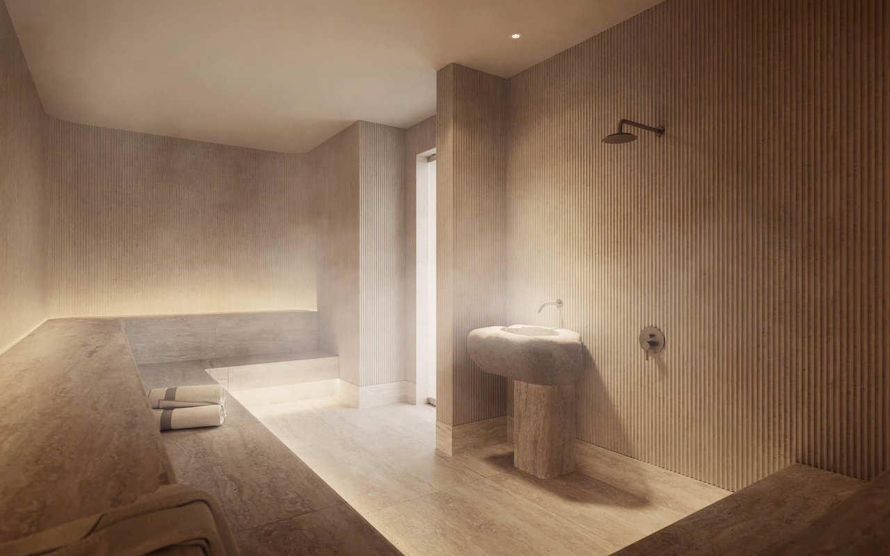 Spa bathroom with a stone bench, folded towels, sculptural basin, and ribbed walls.