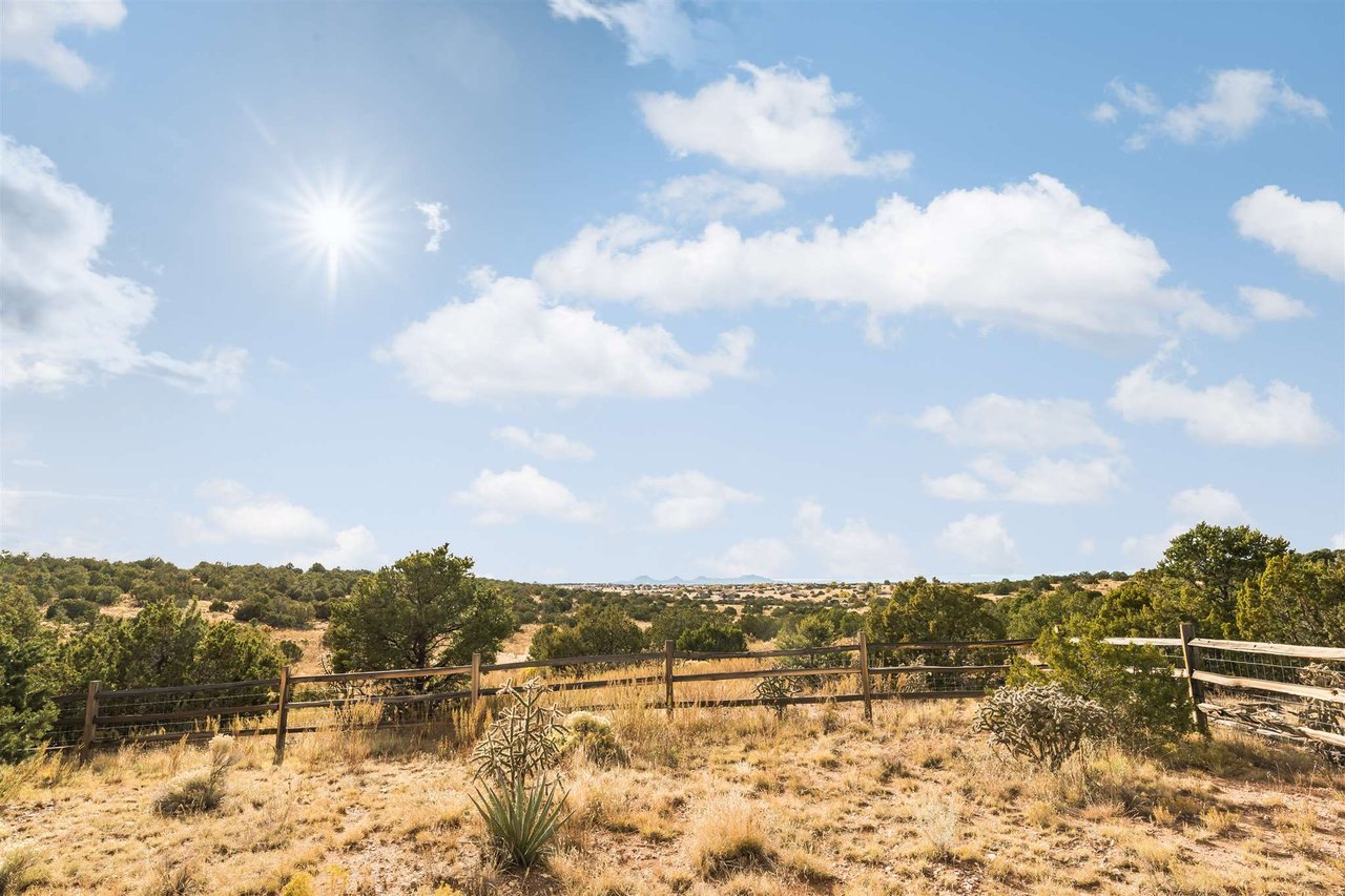 A wooden fence surrounds a dry grass field