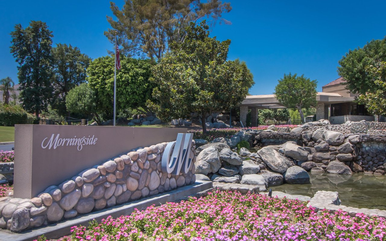 The entrance to Morningside Country Club, featuring a stone sign with the club's name surrounded by colorful flowers