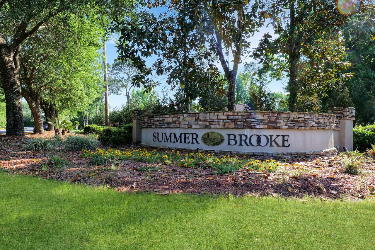 A ground-level view of the entrance sign for "Summerbrooke," indicating the name of the residential community.