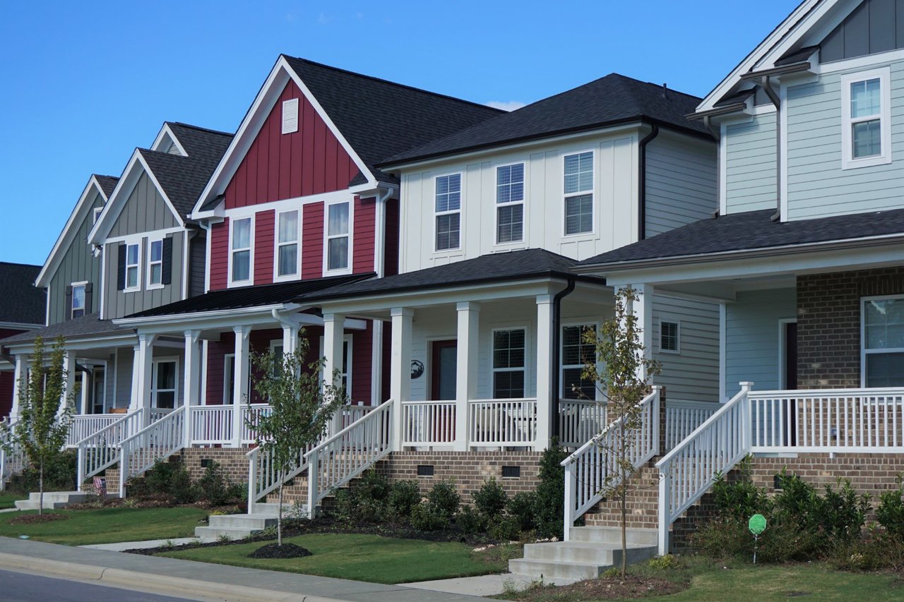 A row of houses with porches and railings in a residential neighborhood.