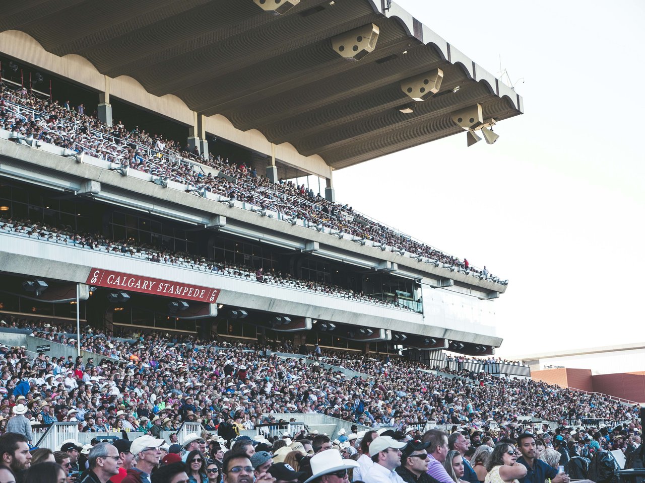 Photo of visitors watching the calgary stampede from the grand stands 