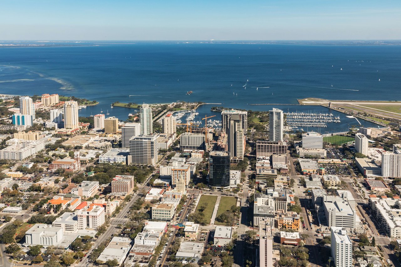 A marina filled with sailboats and yachts is visible on the right side of the bay.