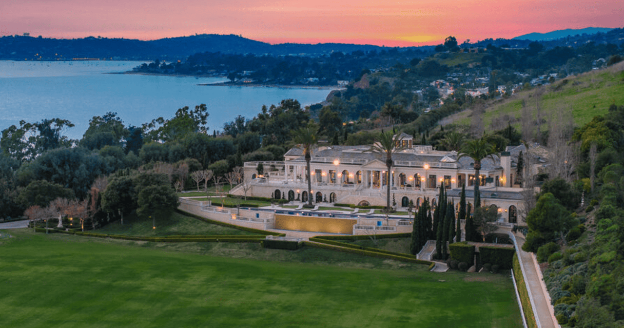 An aerial view of a large Mediterranean-style estate at sunset.