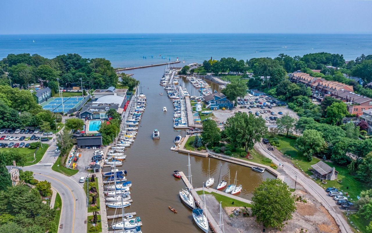 An aerial view of a marina with boats docked in calm blue water.