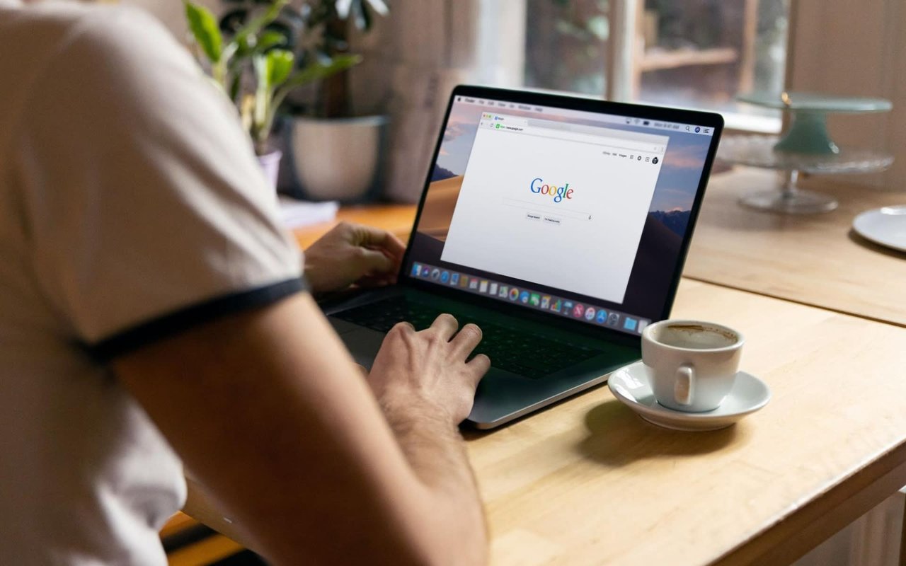 An individual browsing Google on a laptop.