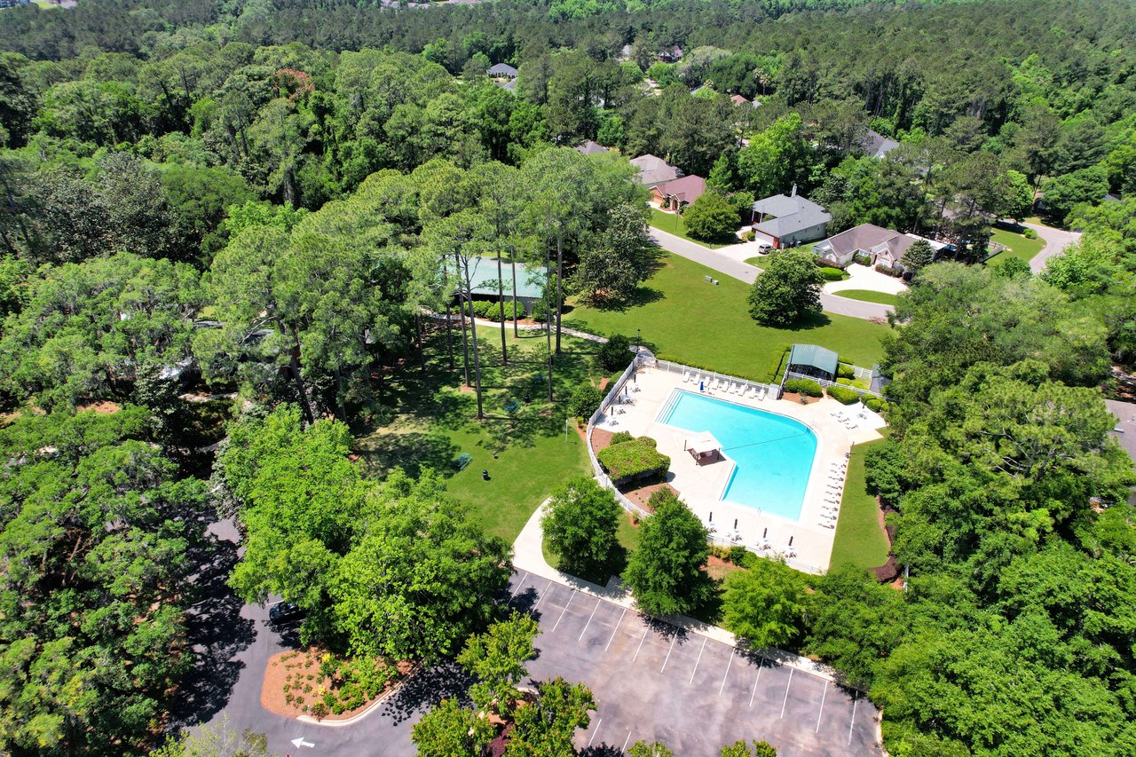 An aerial view of a community pool within the Piney-Z neighborhood, surrounded by houses and trees.