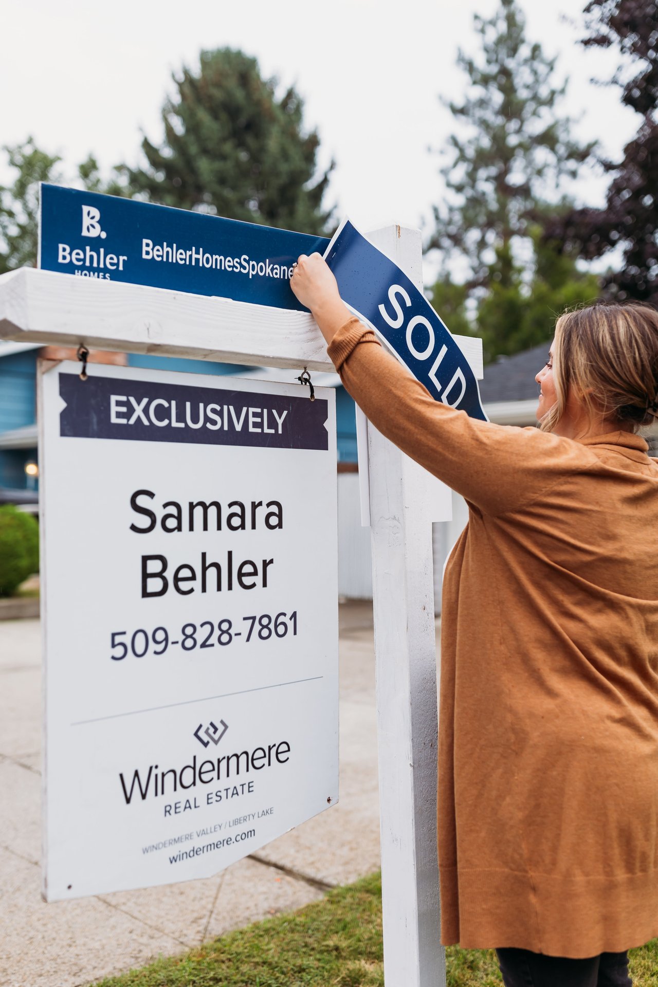 Samara Behler handing a "Sold" sign on a home in Spokane, WA.