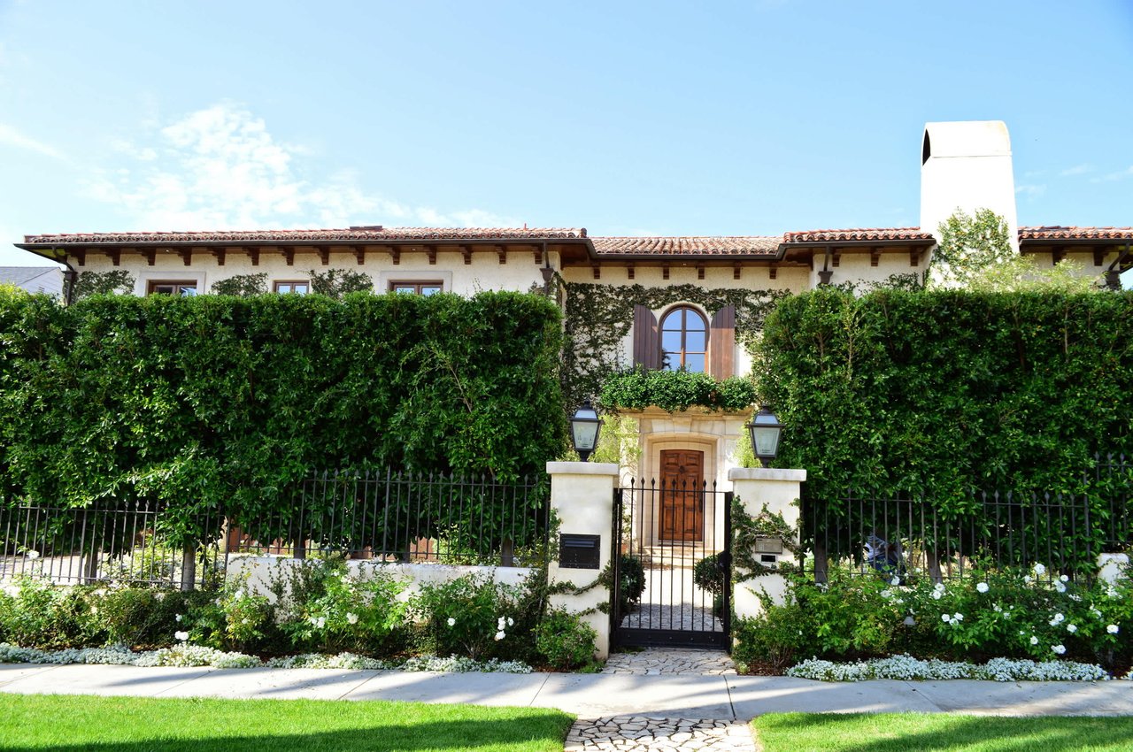 Mediterranean-style home with a tile roof and ivy-covered hedges, free online home valuation by Michele Colombo
