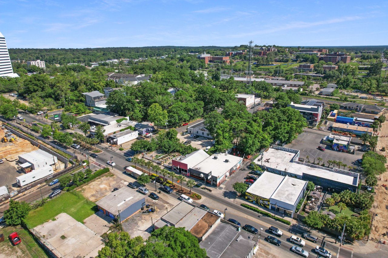 An aerial view of the All Saints community, highlighting a mix of residential and commercial buildings, streets, and green spaces within the urban environment.