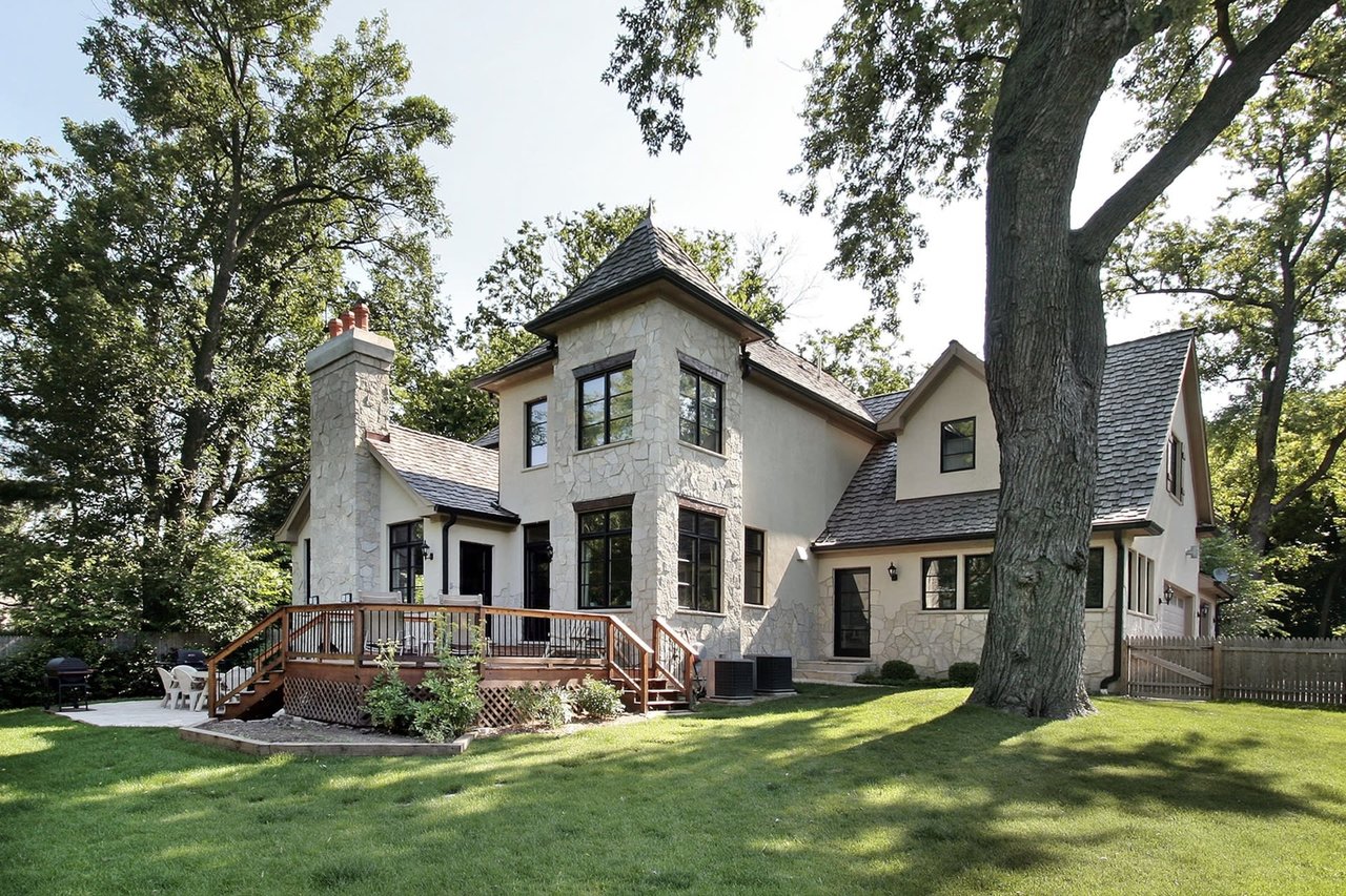 Two-story stone home with a wood deck. Get a home valuation in Montgomery County, TX