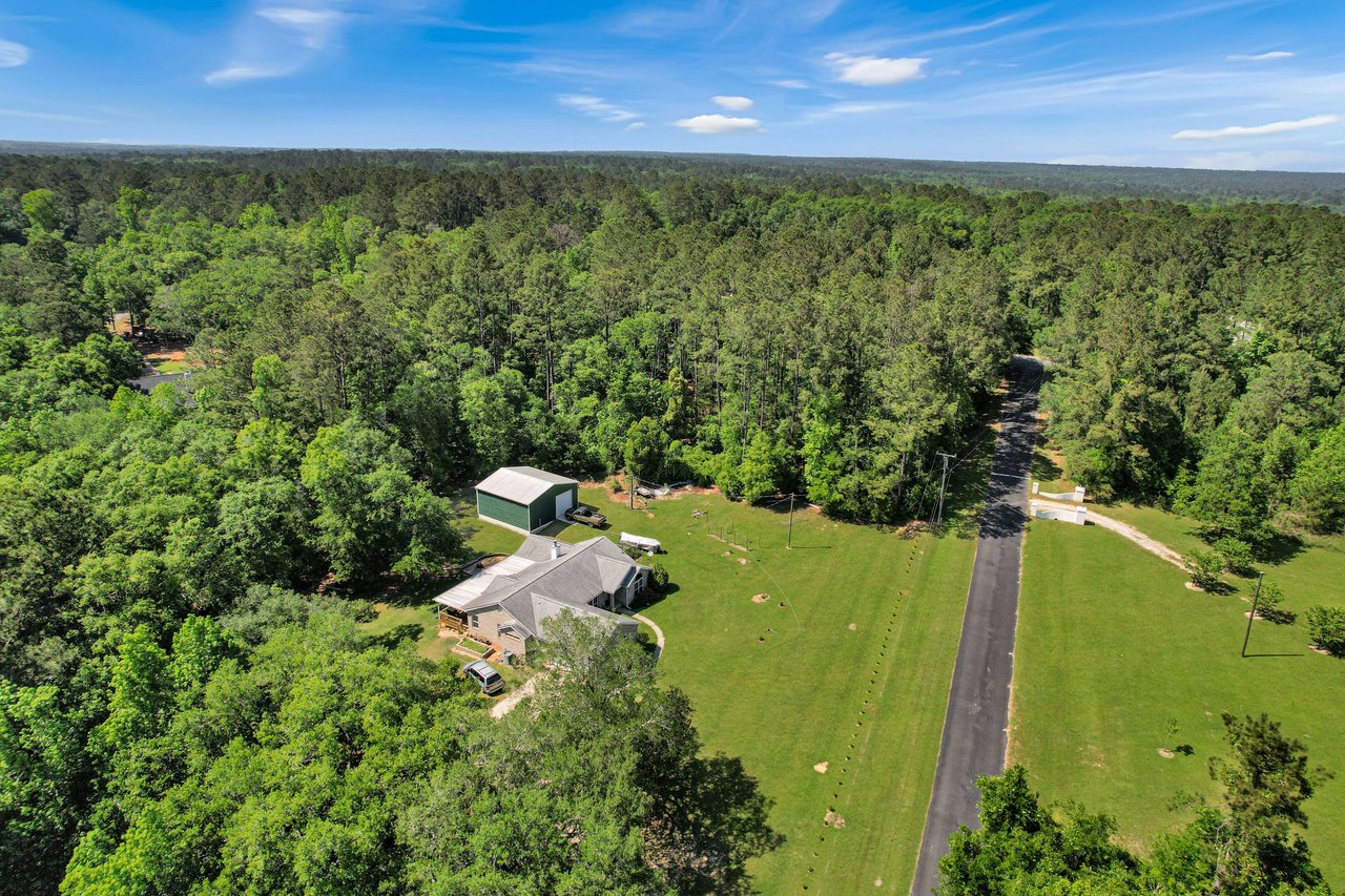 An aerial view of a residential area within the Miccosukee Land Cooperative community, showing houses and roads surrounded by dense greenery.