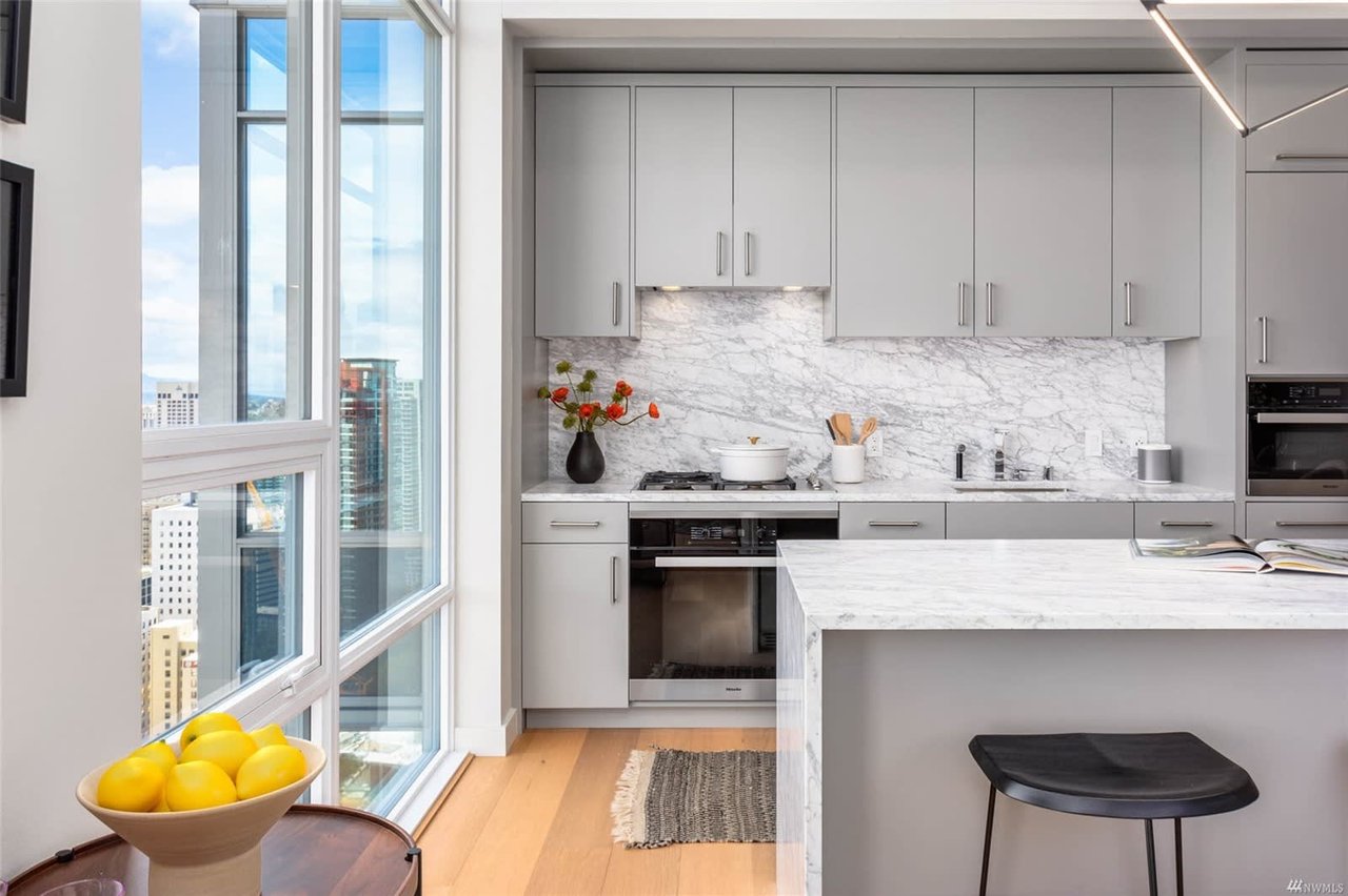 Luxury kitchen with marble counters and city view.