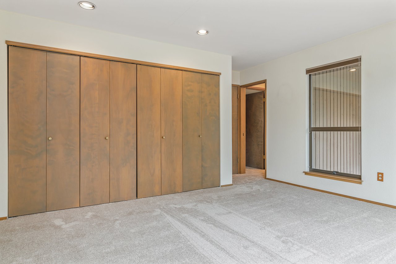 Discover the ultimate convenience with a spacious wall of closets in the primary bedroom, providing ample storage space to keep your wardrobe organized and easily accessible.