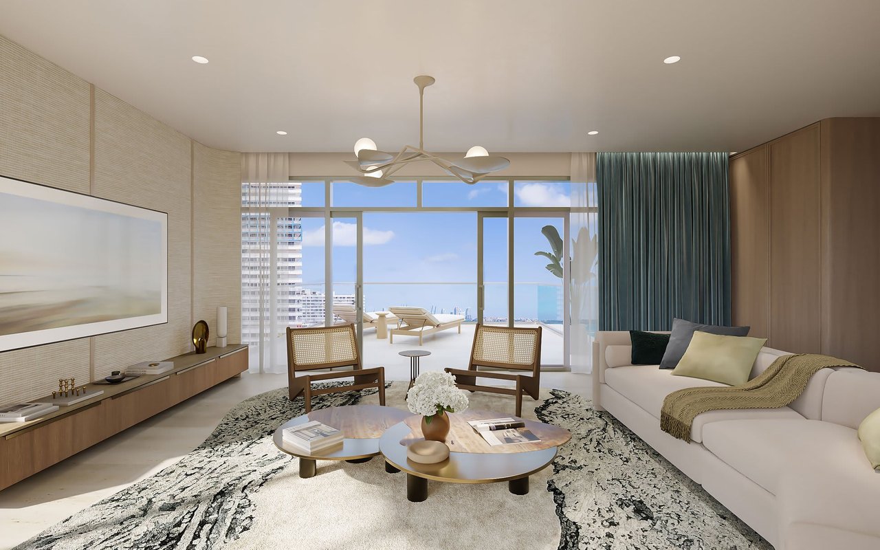 Staged living room with a white sofa, floor-to-ceiling windows, and ocean views.