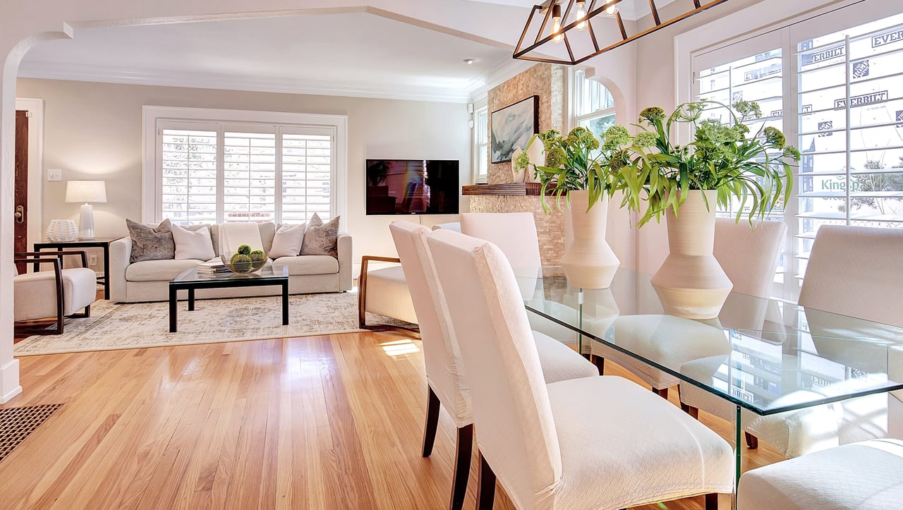 A modern dining room with a glass table and white chairs