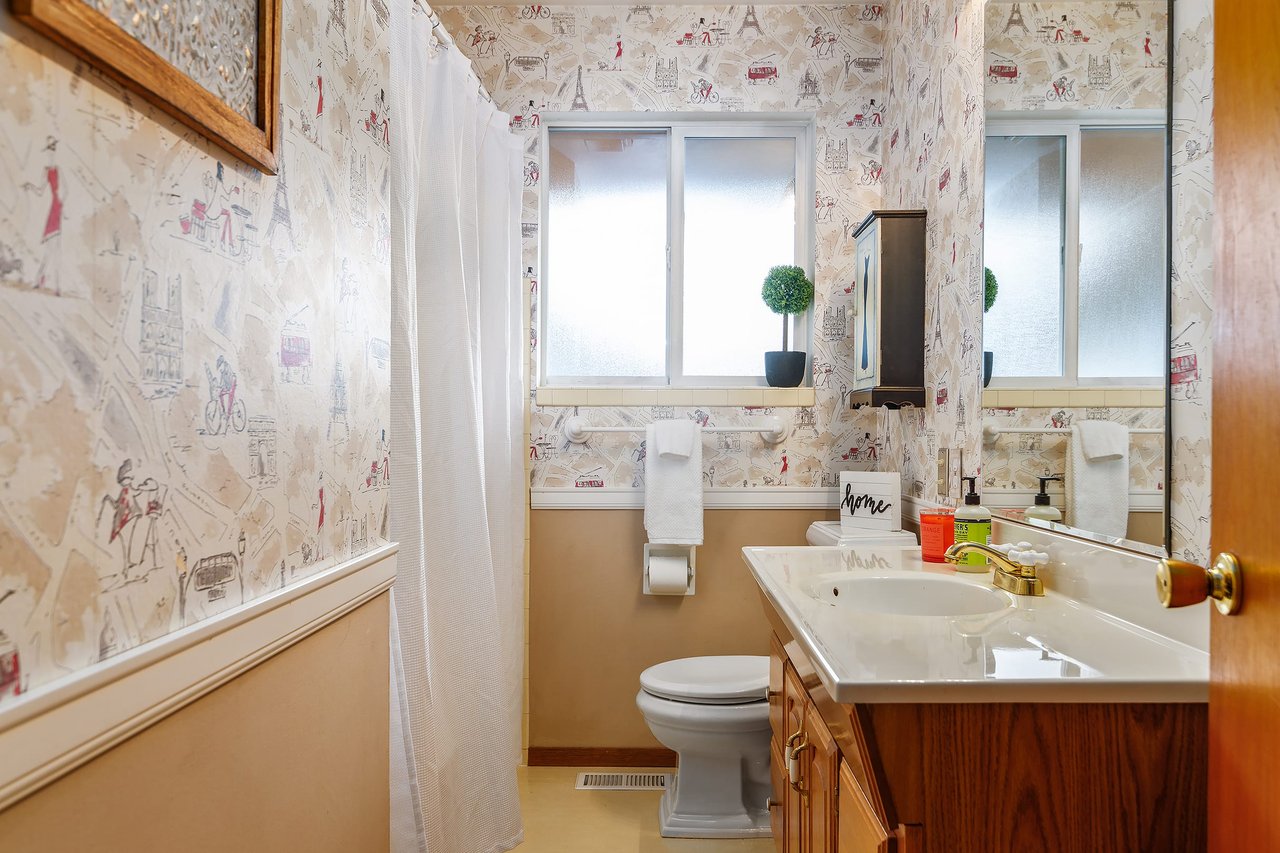 Explore charm in the guest bath and admire the unique touch of wallpaper, adding character to this welcoming space.