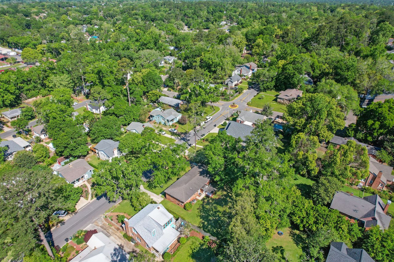 Aerial view of a residential area in Old Town with houses and dense tree cover.