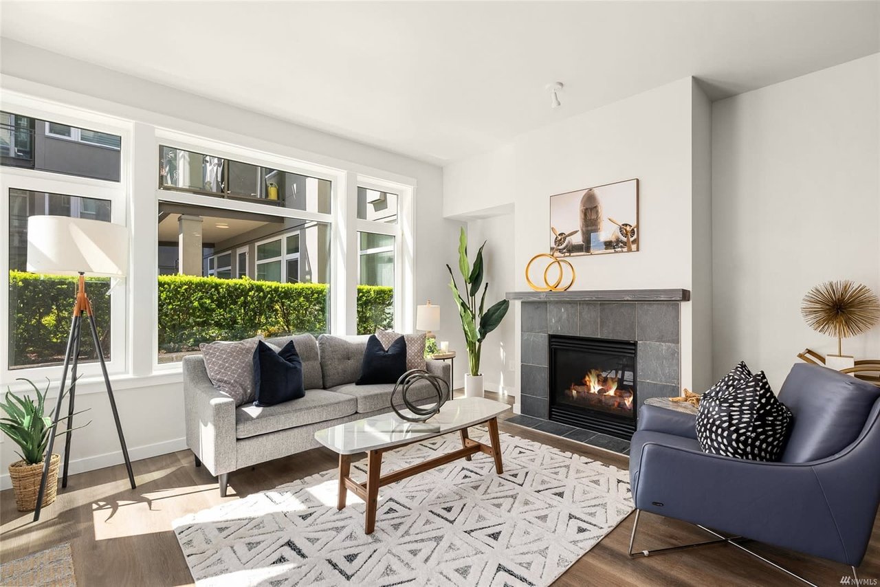 Luxury condo living room with cozy fireplace, chic décor, and abundant natural light.