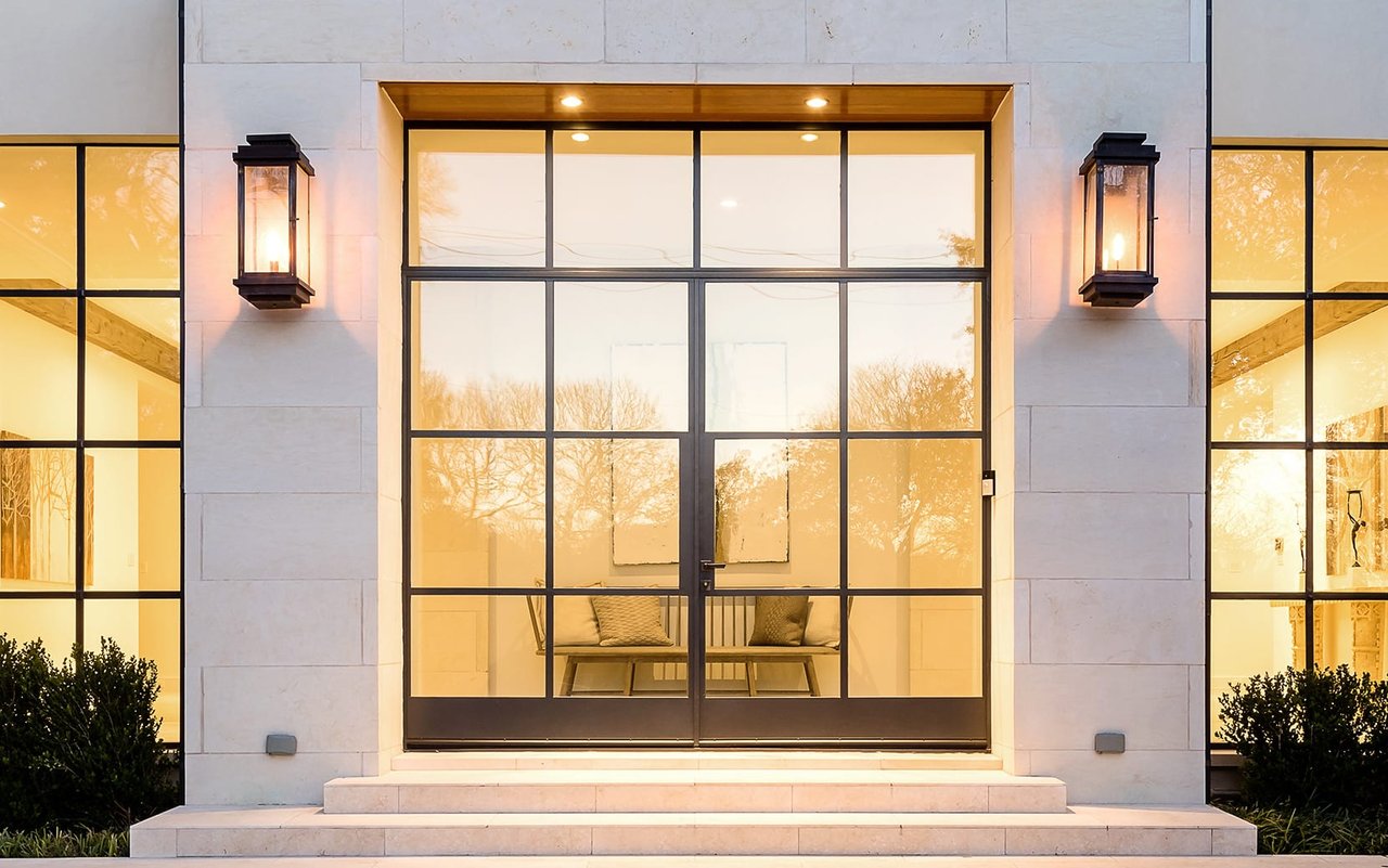 A large custom door with clean modern lines in a spacious and well-lit entryway of a modern home.