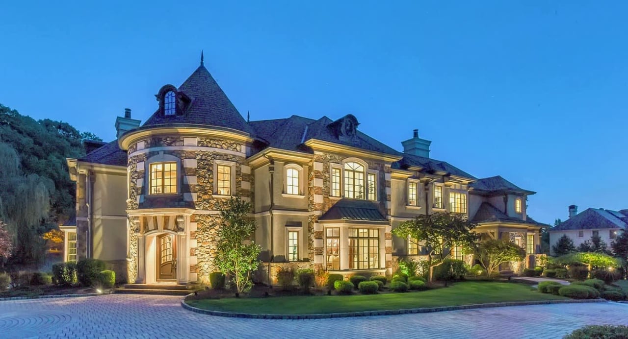 Large mansion in the sunset with lights on inside