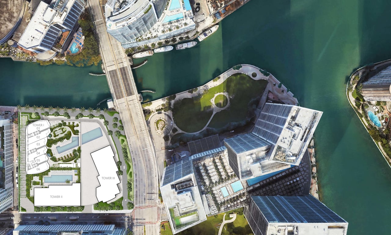 Aerial view of a waterfront development site with a three-tower plan beside a bridge.