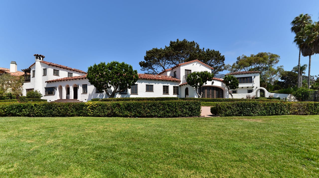 Spanish-style home in Sunset Cliffs, San Diego, with arched details and red tile roof at sunset.