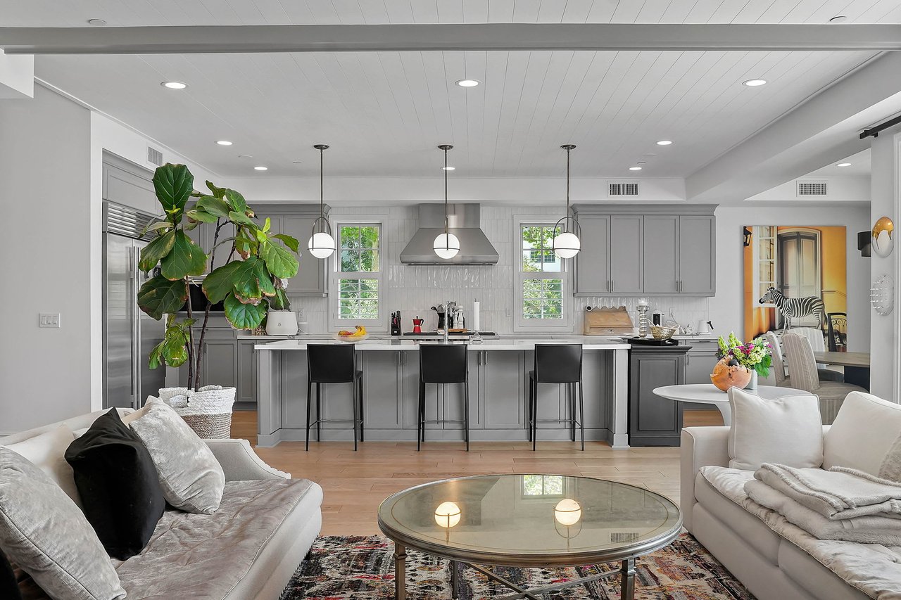  A modern open-concept living space features a gray kitchen in the background and a cozy living room 