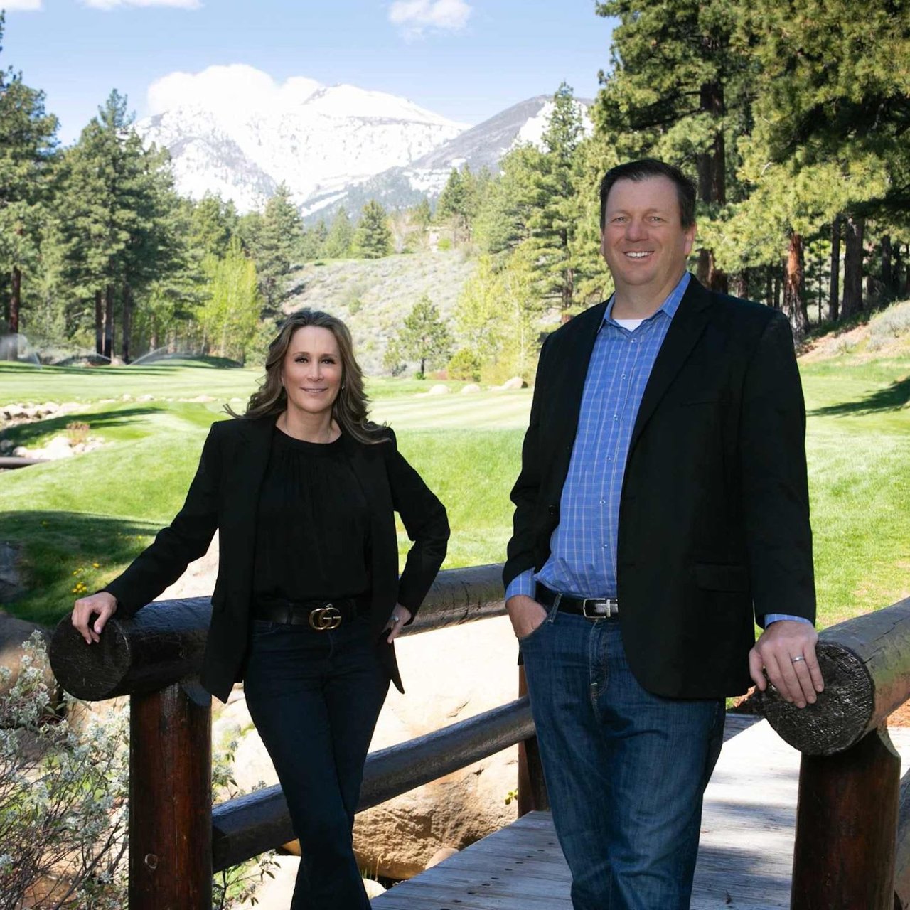 The Becker-Herman team, Montreux luxury real estate experts, posing outdoors with snow-capped mountains and lush golf course views.