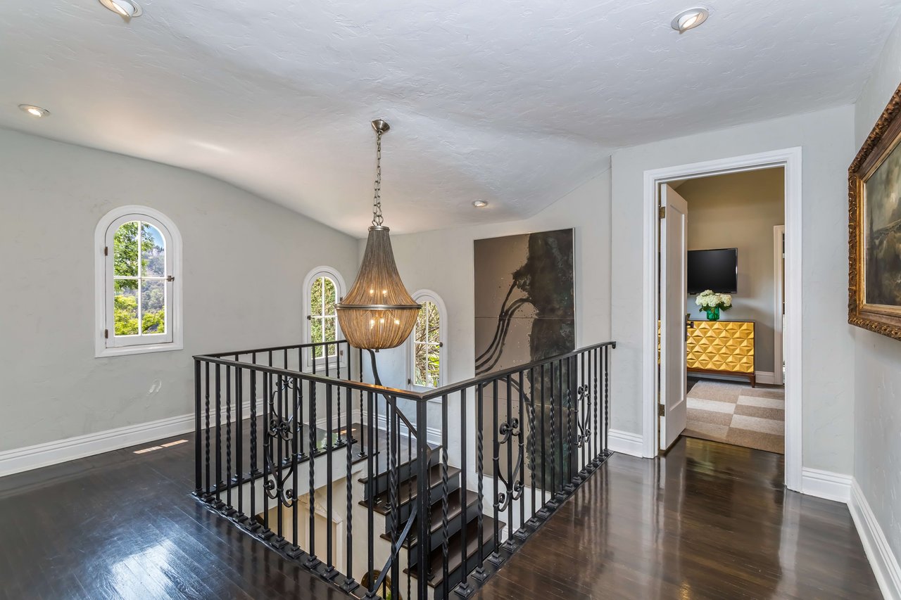 Hallway of past listing at 3308 n. Knoll Drive with hanging chandelier and artwork hanging on walls.